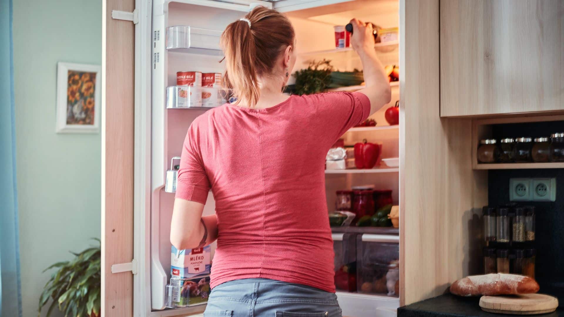 Woman checking the fridge lifespan